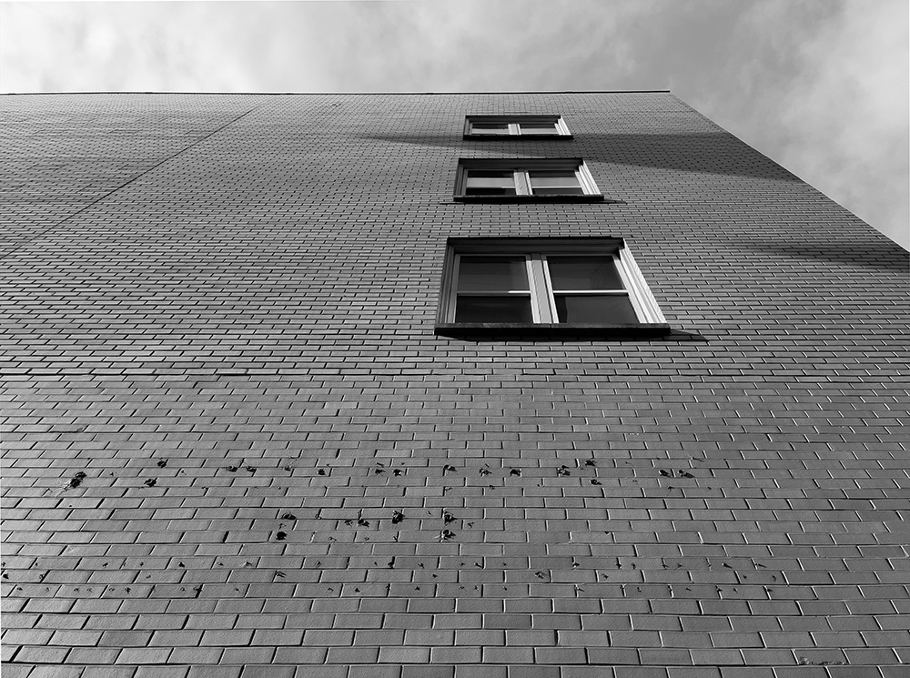 Modernistic Photo of Brick Wall, Windows, and Sky.